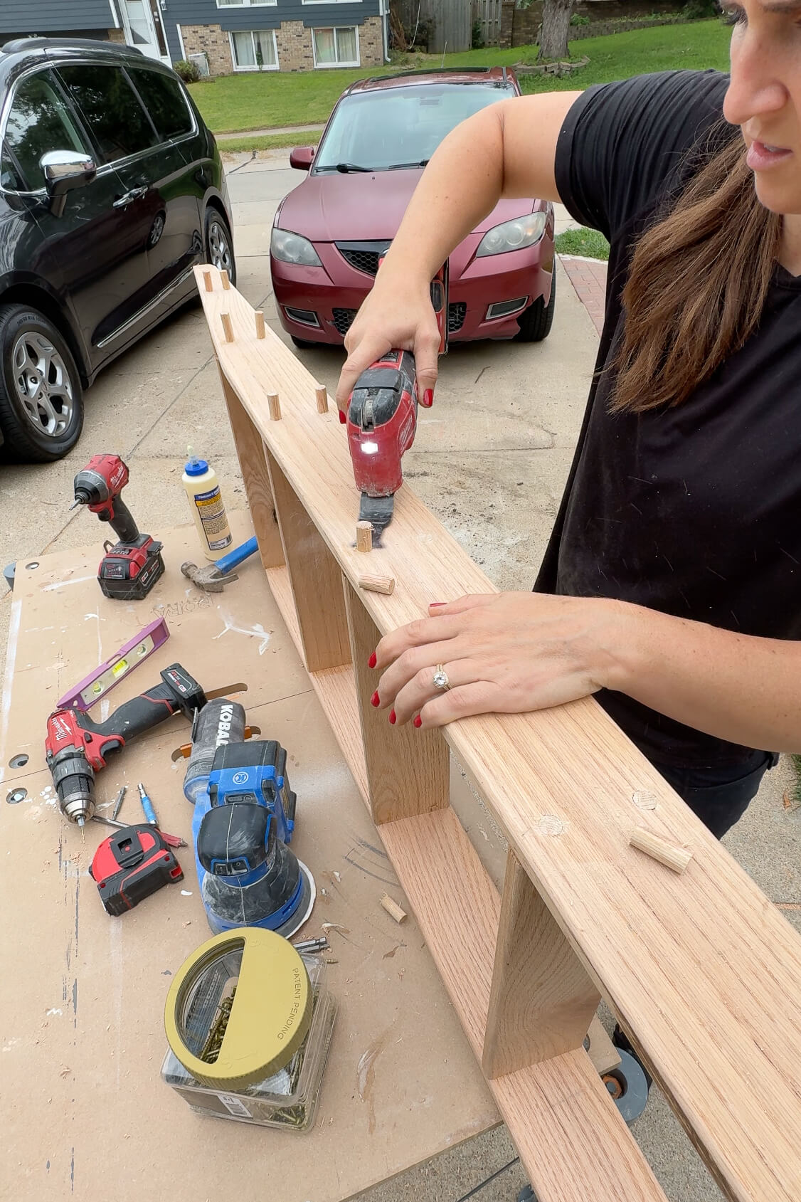 Adding dowels to cover screw holes on a ladder for DIY bunk beds.